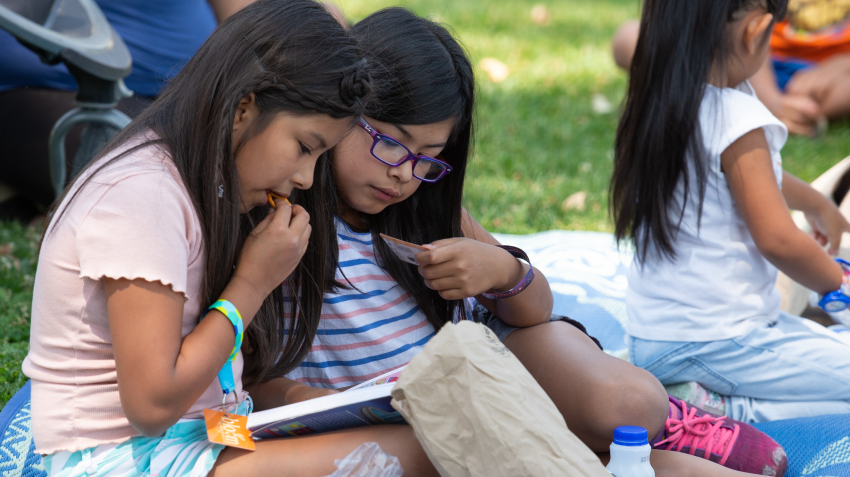 two children read and eat snacks at the Bloom mobile bookmobile