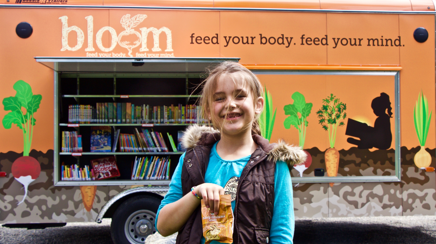 a child standing in front of the Bloom truck