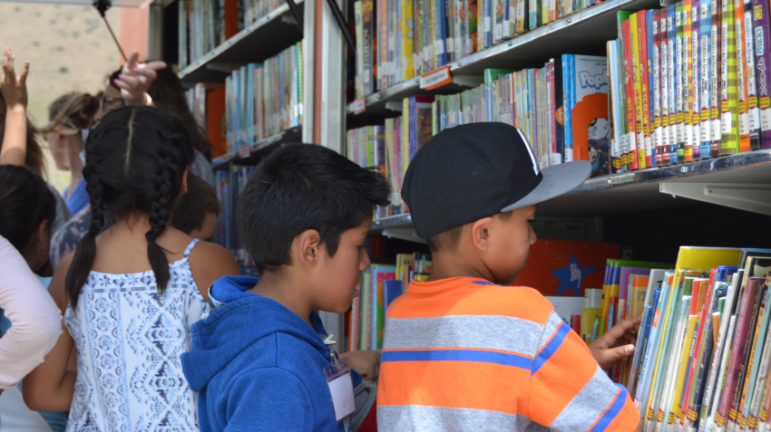 a crowd of children selecting books