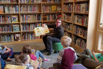 Craig Barry, Gold Mine Managing Director, reads a story in the Children's Library.