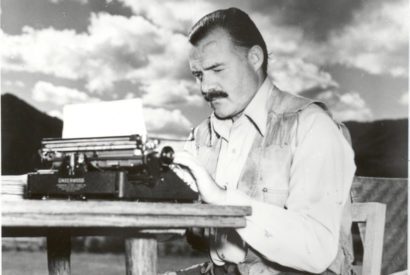 Hemingway typing outdoors