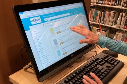 Person using catalog in Library.