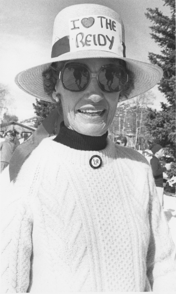 Woman wearing hat with sign saying "I heart the Reidy".