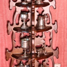 Display stand with silver pitchers, cups and goblets. Étagère
